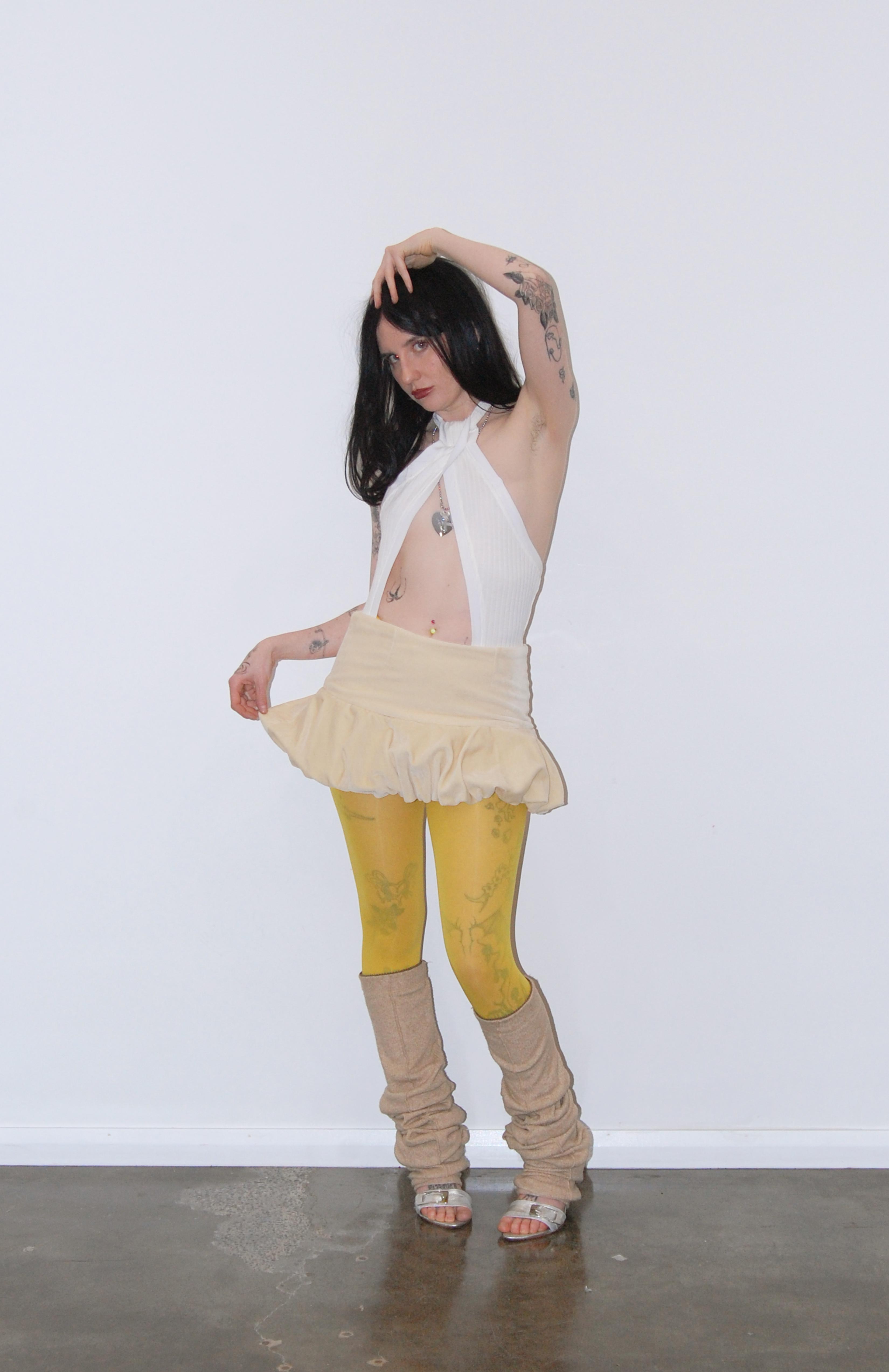 Maroske Peech A flirty playful bubble mid waisted mini skirt that salutes the fashion trends of the 1980s. This mid rise puffball style is created with a crinoline inner foundation to hold its balloon-like shape. A wonderful way to add volume to a silhouette.