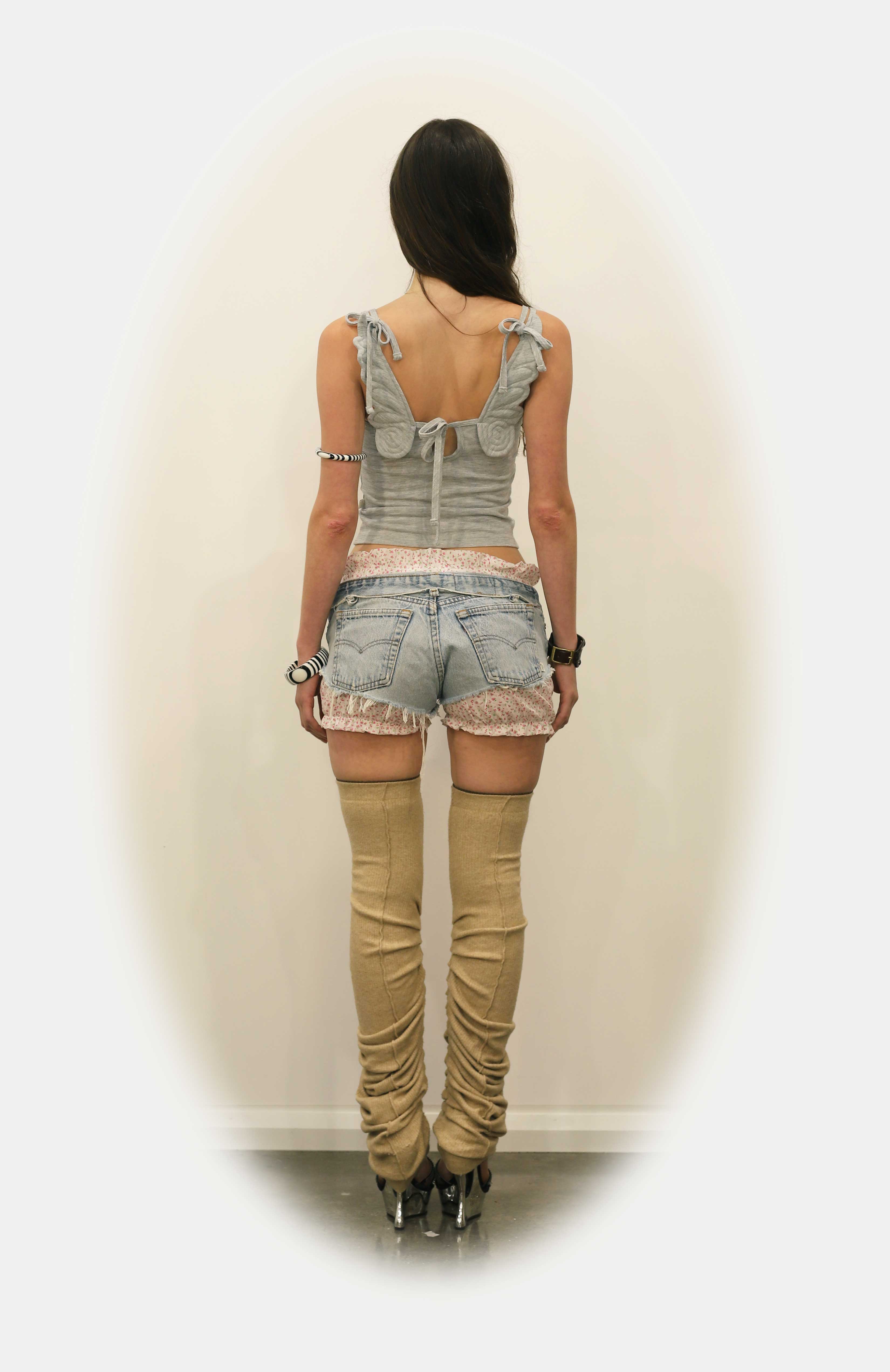 A Maroske Peech Signature, features handmade plushie angel wings, dual shoulder straps and a keyhole opening at the back tied closed with a bow.