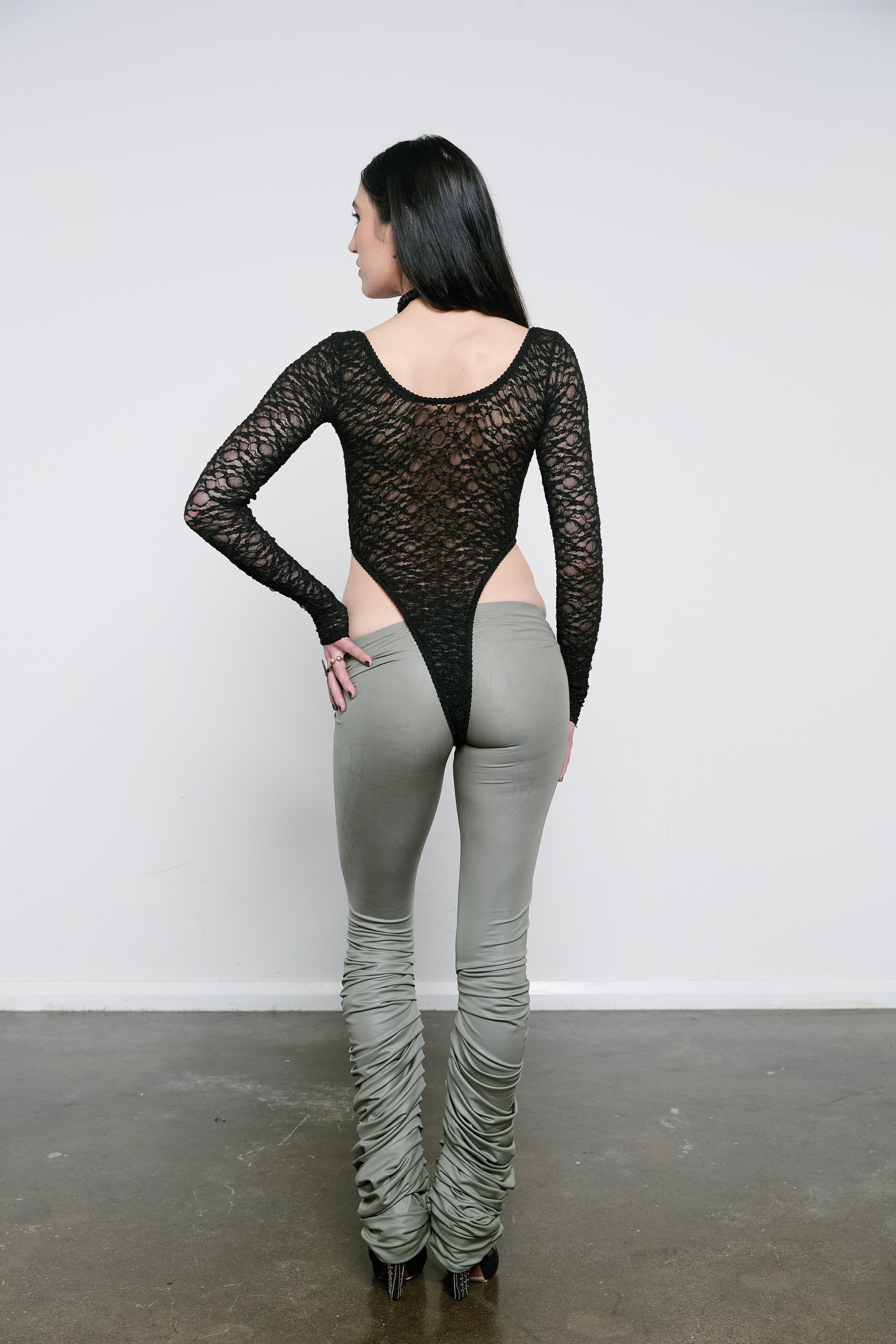 High rise iron coloured wet look leggings with a pleated inseam. Volume starts from the knee and drapes down over the foot for a lamb leg effect.