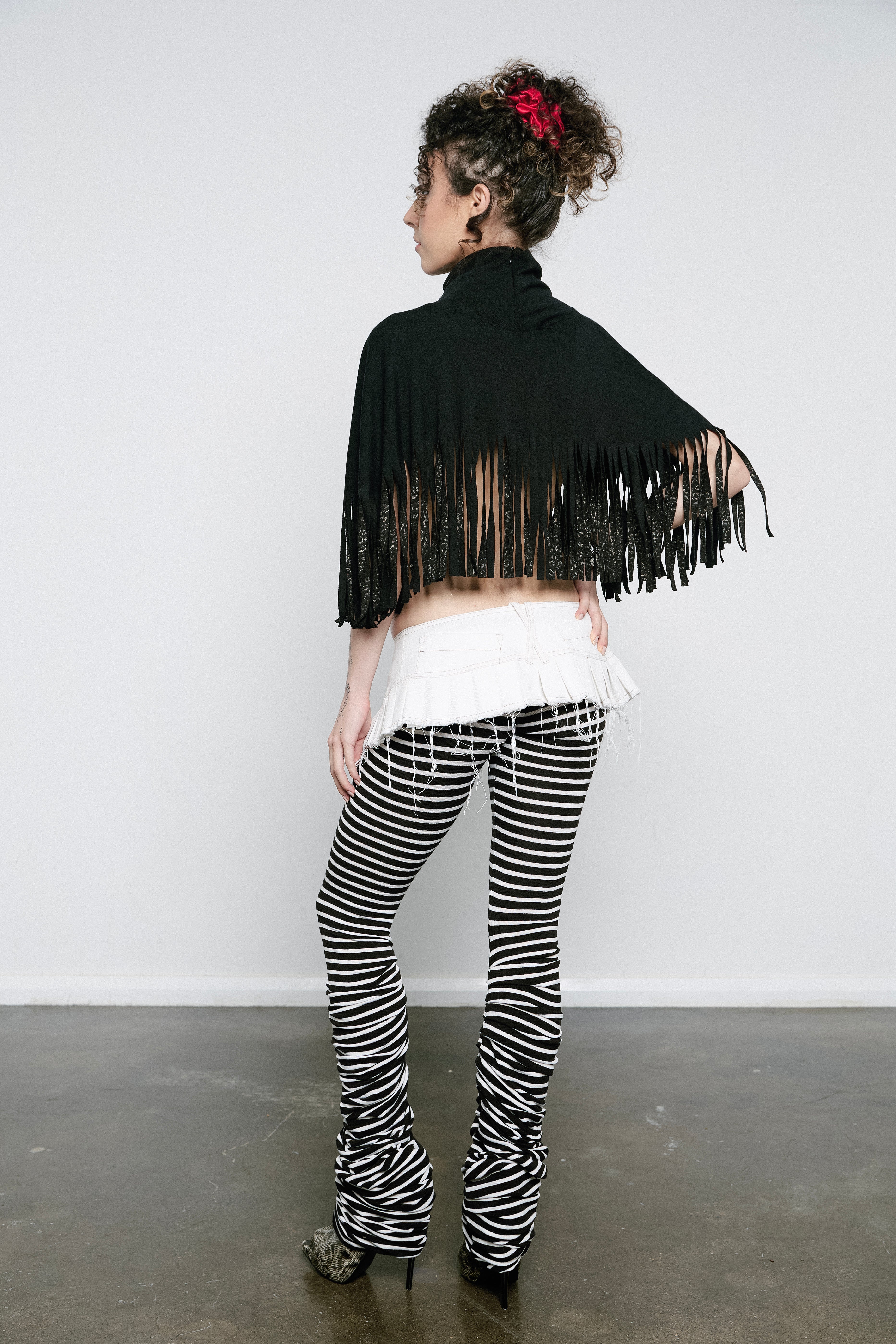 High rise monochrome stripe leggings with a pleated inseam. Volume starts from the knee and drapes down over the foot for a lamb leg effect.