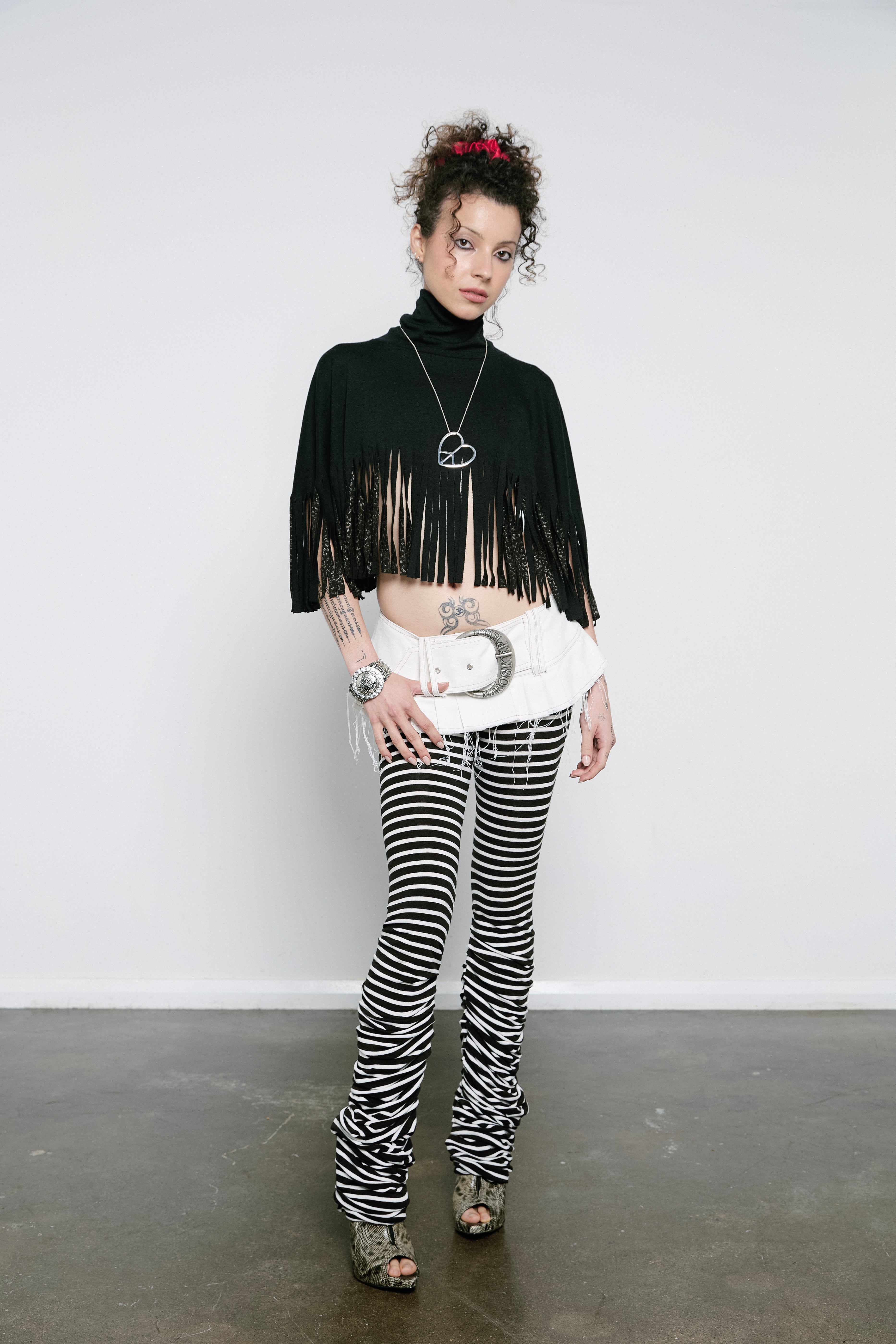 High rise monochrome stripe leggings with a pleated inseam. Volume starts from the knee and drapes down over the foot for a lamb leg effect.