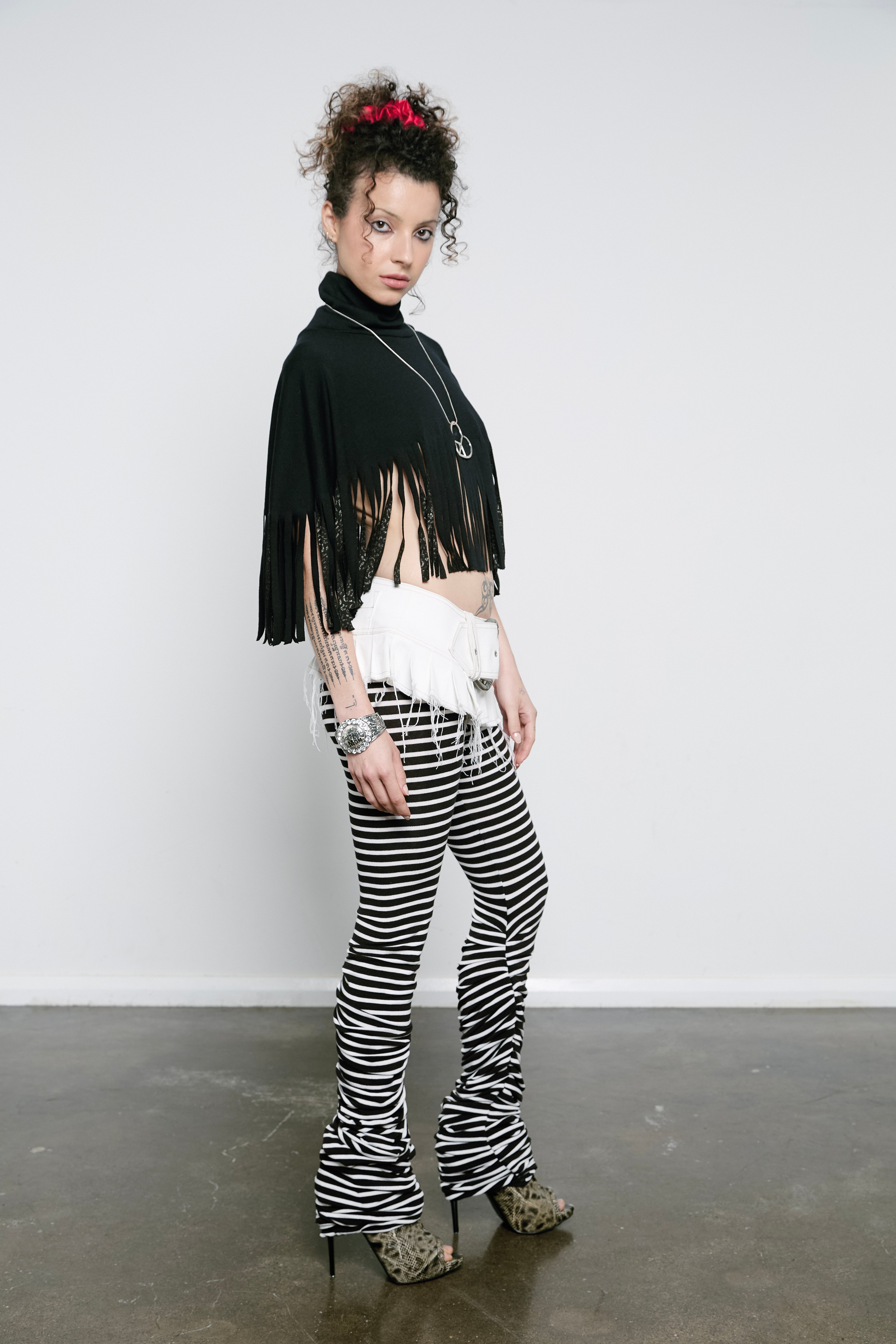 High rise monochrome stripe leggings with a pleated inseam. Volume starts from the knee and drapes down over the foot for a lamb leg effect.