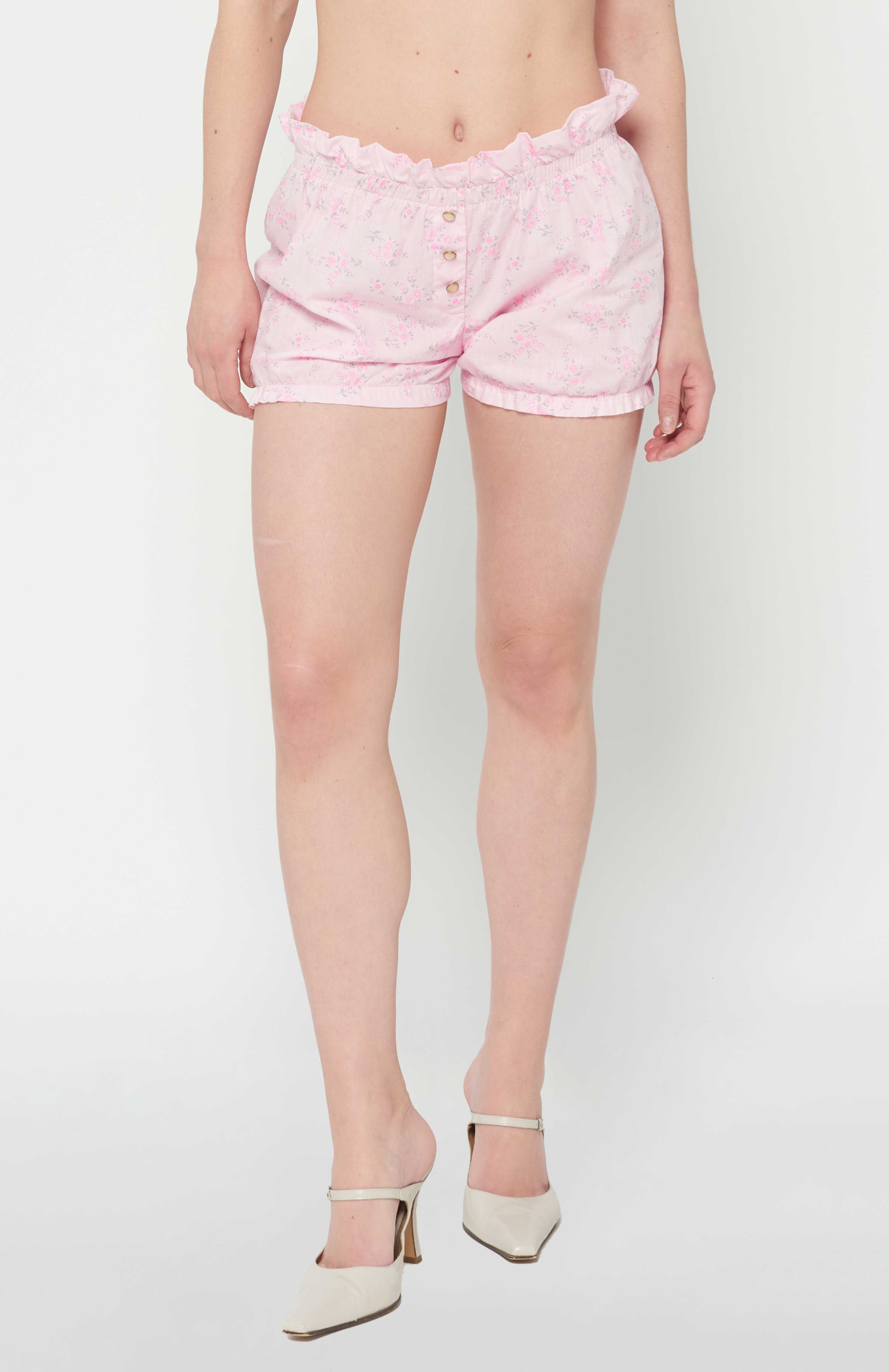 Maroske Peech high waisted cotton playful bloomer for special occasions. Featuring a soft stretchy ruffle waistband and hem.   Fashioned in a light weight woven pink floral. A handy patch pocket is positioned on back. Can be easily styled under short skirts, over leggings for modesty and alternatively on its own during the warmer months.