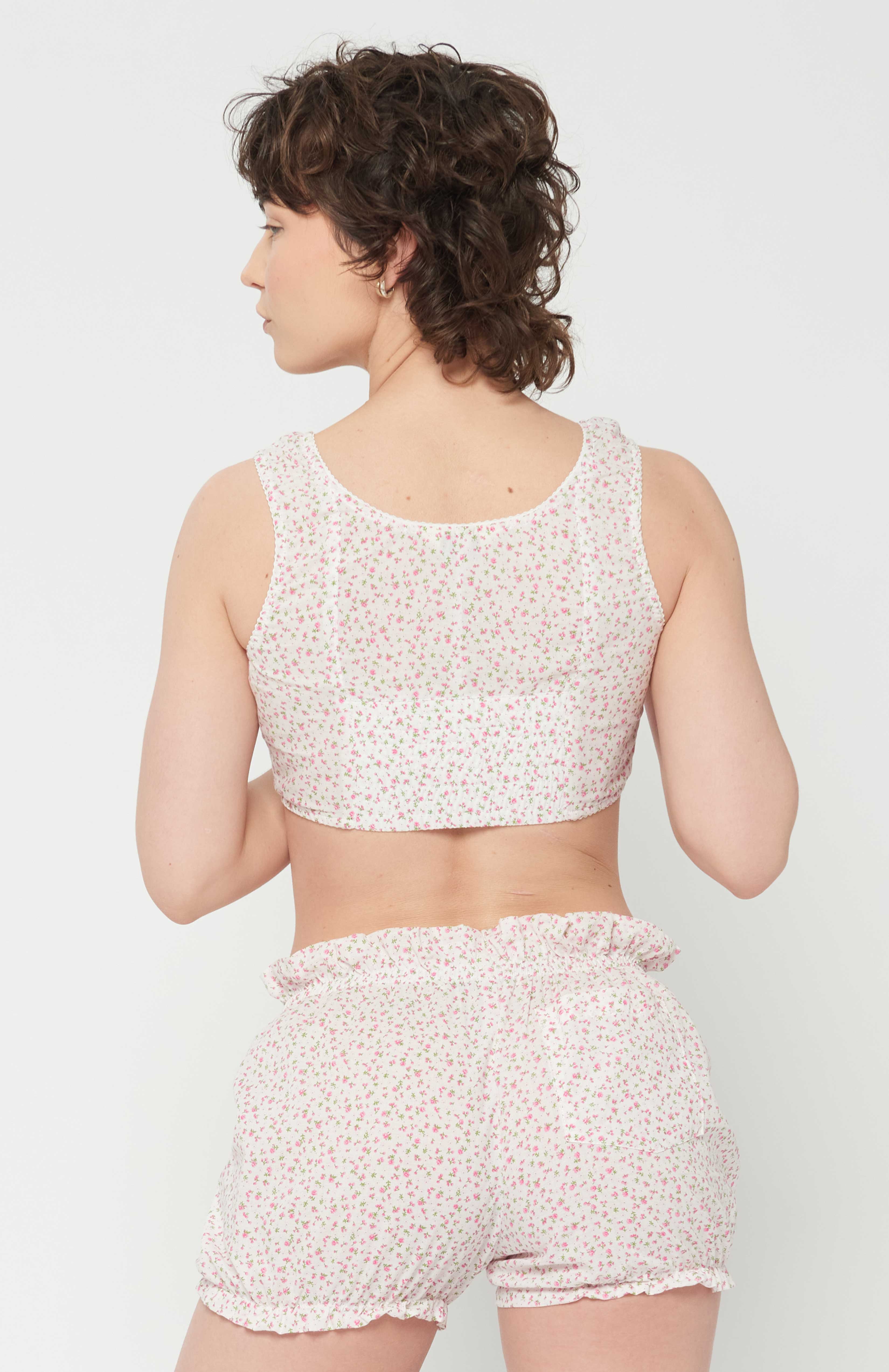 Maroske Peech playful cropped white floral bustier is an updated classic of an era gone by. The bust-line gathers facilitates and creates a feminine shape. Features scalloped lace elastic finishings, a tidy hook and eye centre front closure finishes off the sweatheart neckline.