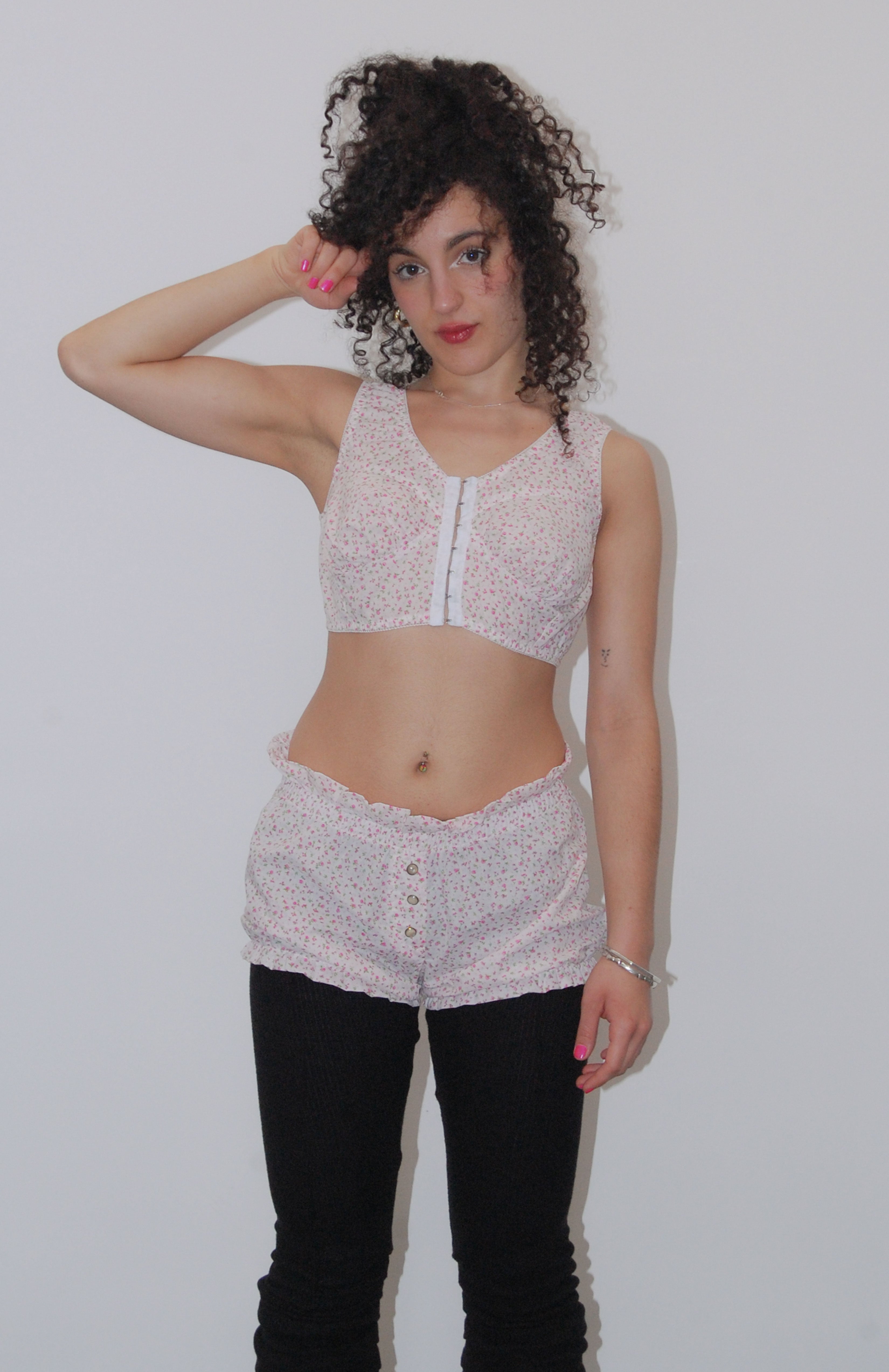 This playful cropped white floral bustier is an updated classic of an era gone by. The bust-line gathers facilitates and;creates a feminine shape. Features scalloped lace elastic finishings, a tidy hook and eye centre front closure finishes off the sweatheart neckline