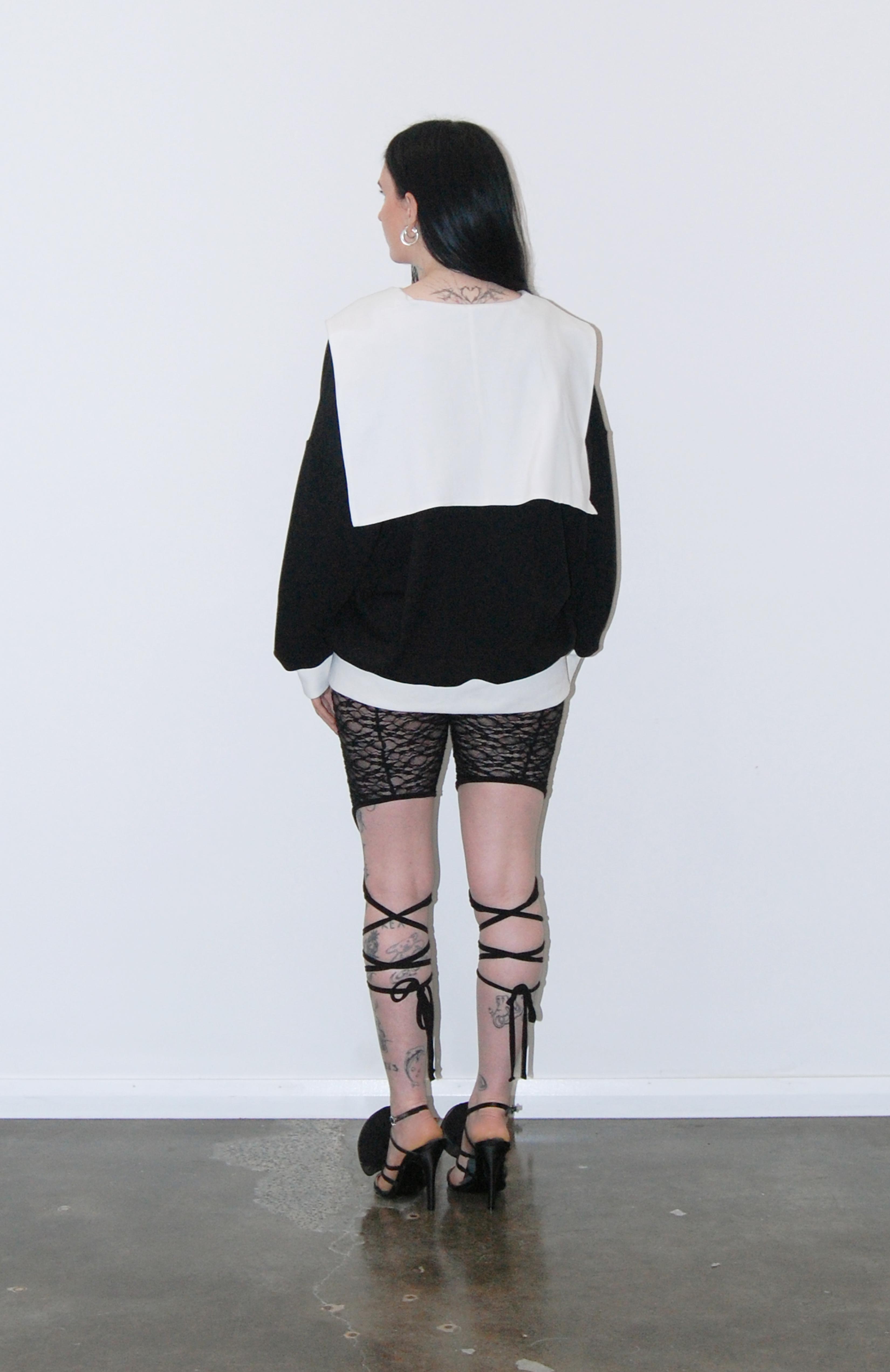 An oversized soft knit black jersey sweater with romantic white V-neck sailor collar. Features complimentary white rib accent cuffs and hem. This cosy style is a sophisticated alternative to a hoodie that can be easily dressed up or down. Perfect for provoking a glamorous yet bitter sweet adventure.