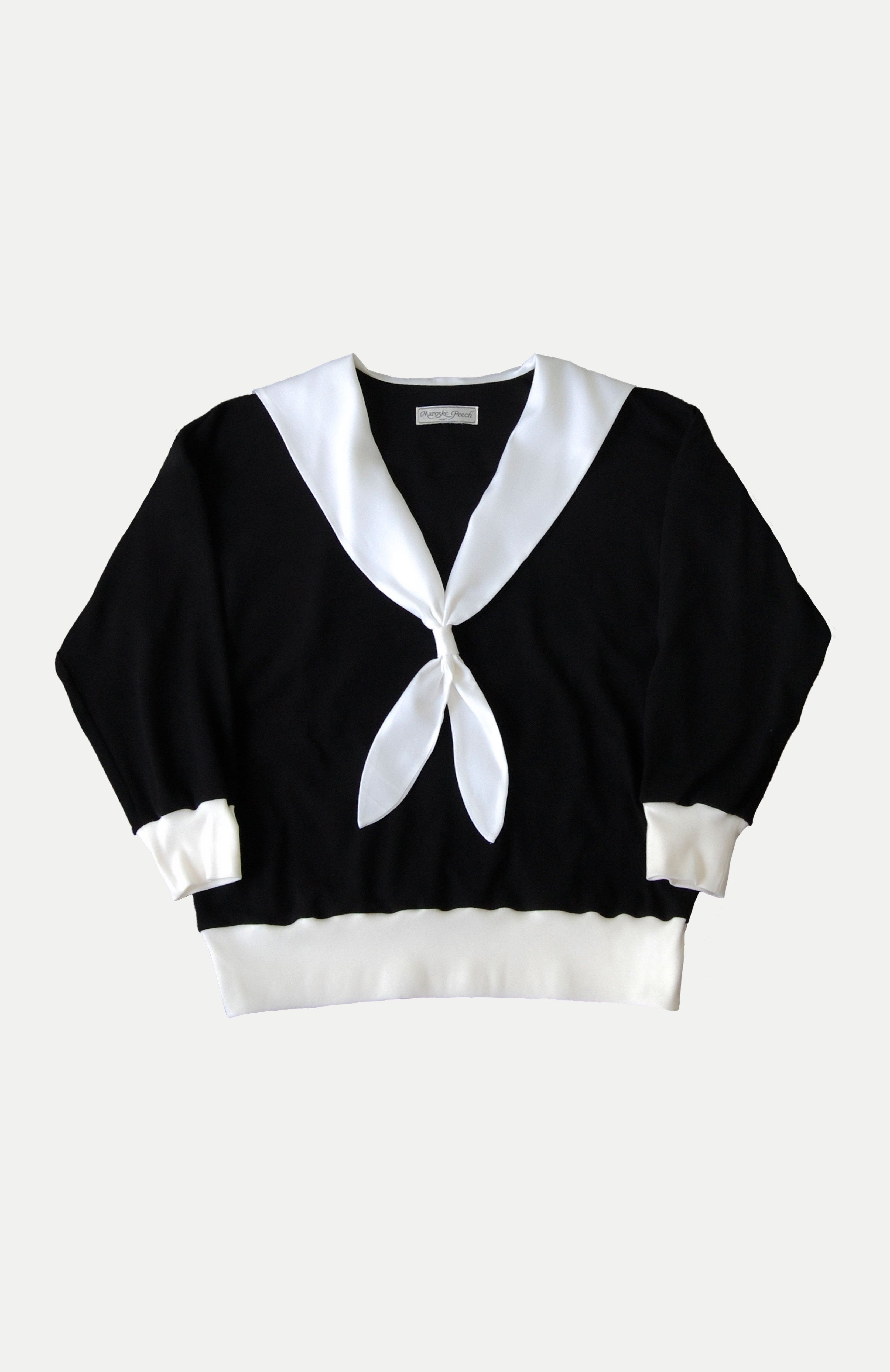 An oversized soft knit black jersey sweater with romantic white V-neck sailor collar. Features complimentary white rib accent cuffs and hem. This cosy style is a sophisticated alternative to a hoodie that can be easily dressed up or down. Perfect for provoking a glamorous yet bitter sweet adventure.