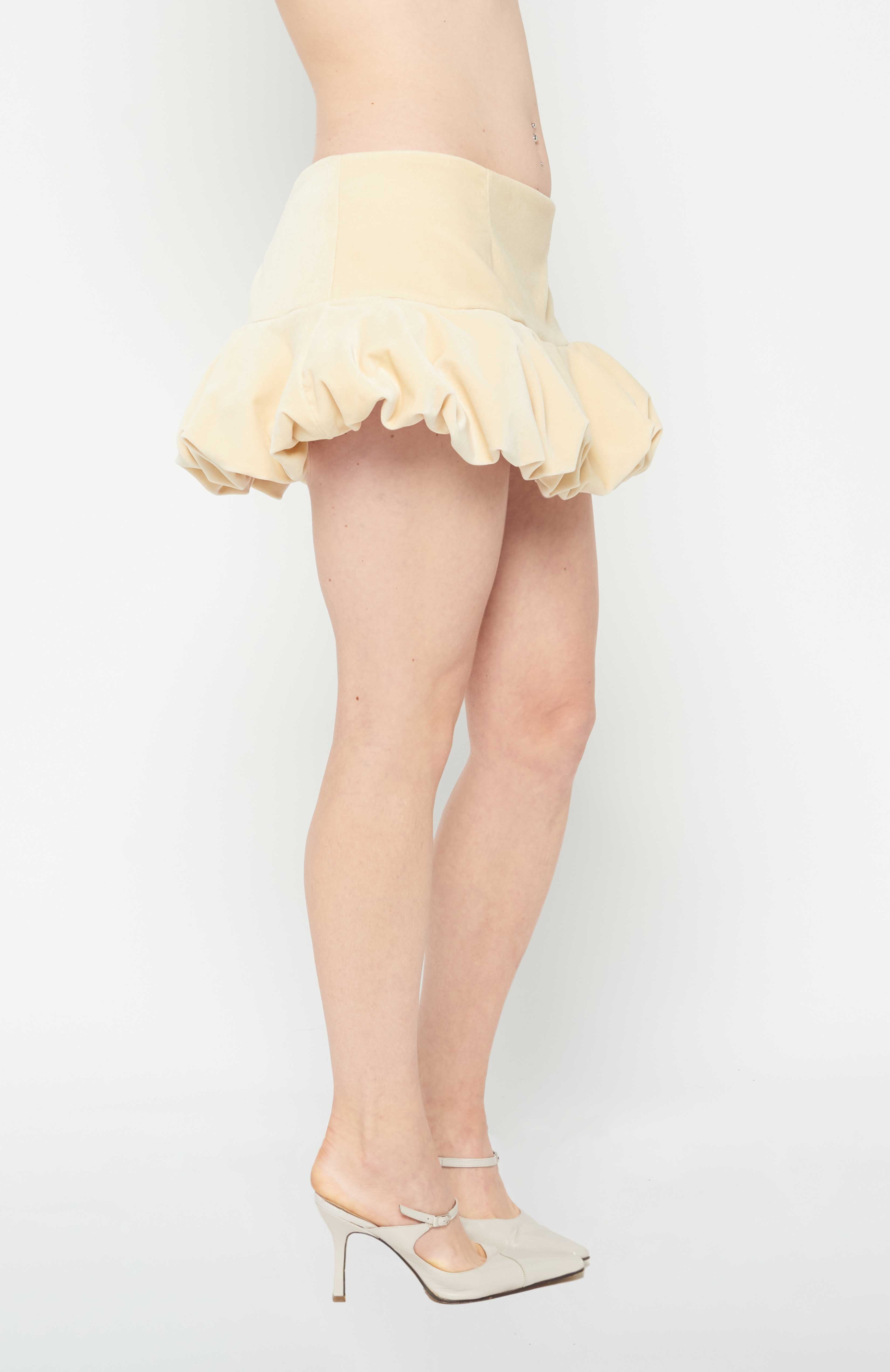 A flirty playful bubble mid waisted mini skirt that salutes the fashion trends of the 1980s. This mid rise puffball style is created with a crinoline inner foundation to hold its balloon-like shape. A wonderful way to add volume to a silhouette.