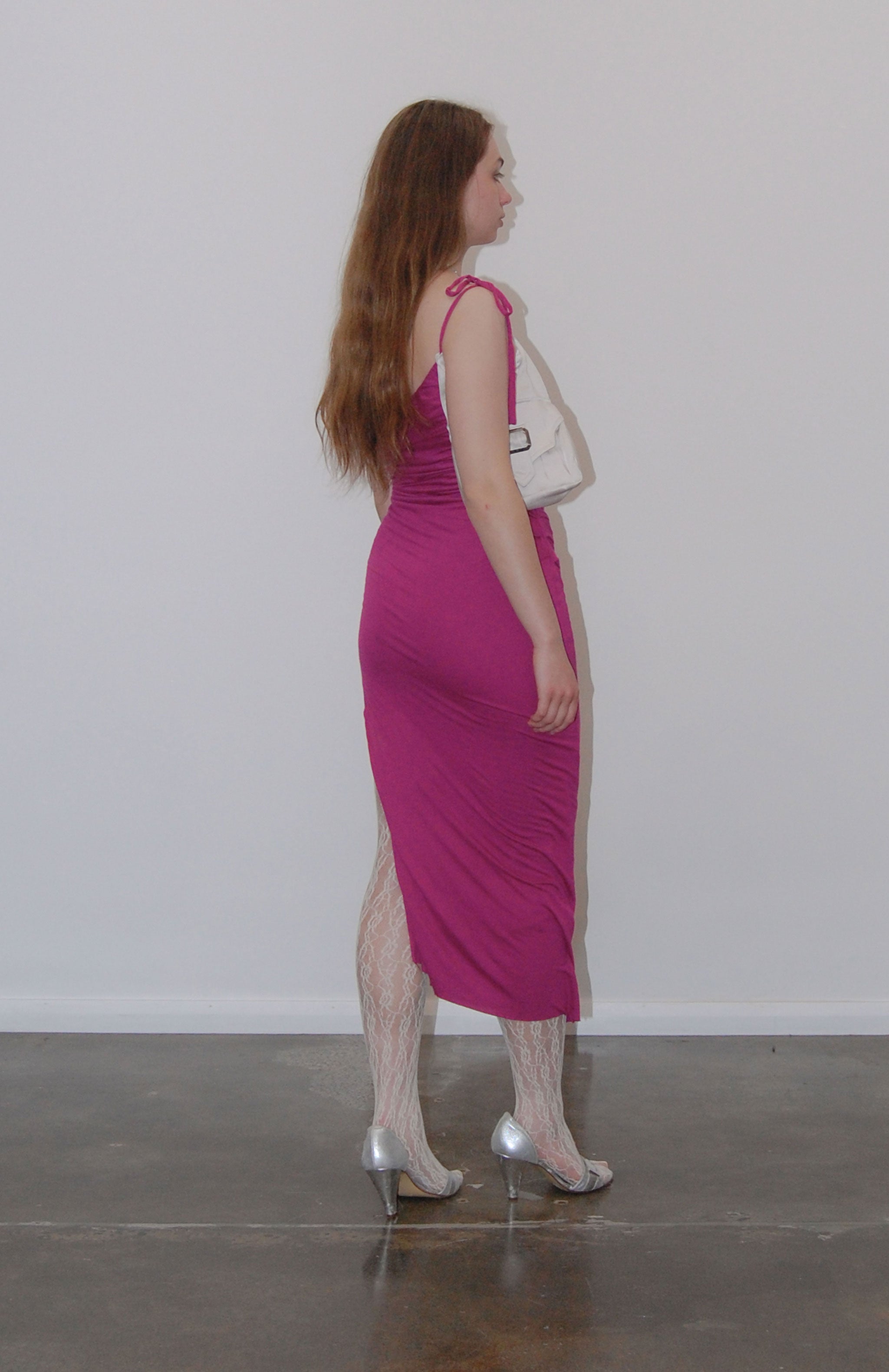Mid length maxi dress in fuchsia jersey with attached Navy purse pocket. Features, flattering pleats from underarm to the high hip Thigh high slit and adjustable tie spaghetti strap. fully lined with square buckle and magnetic button.