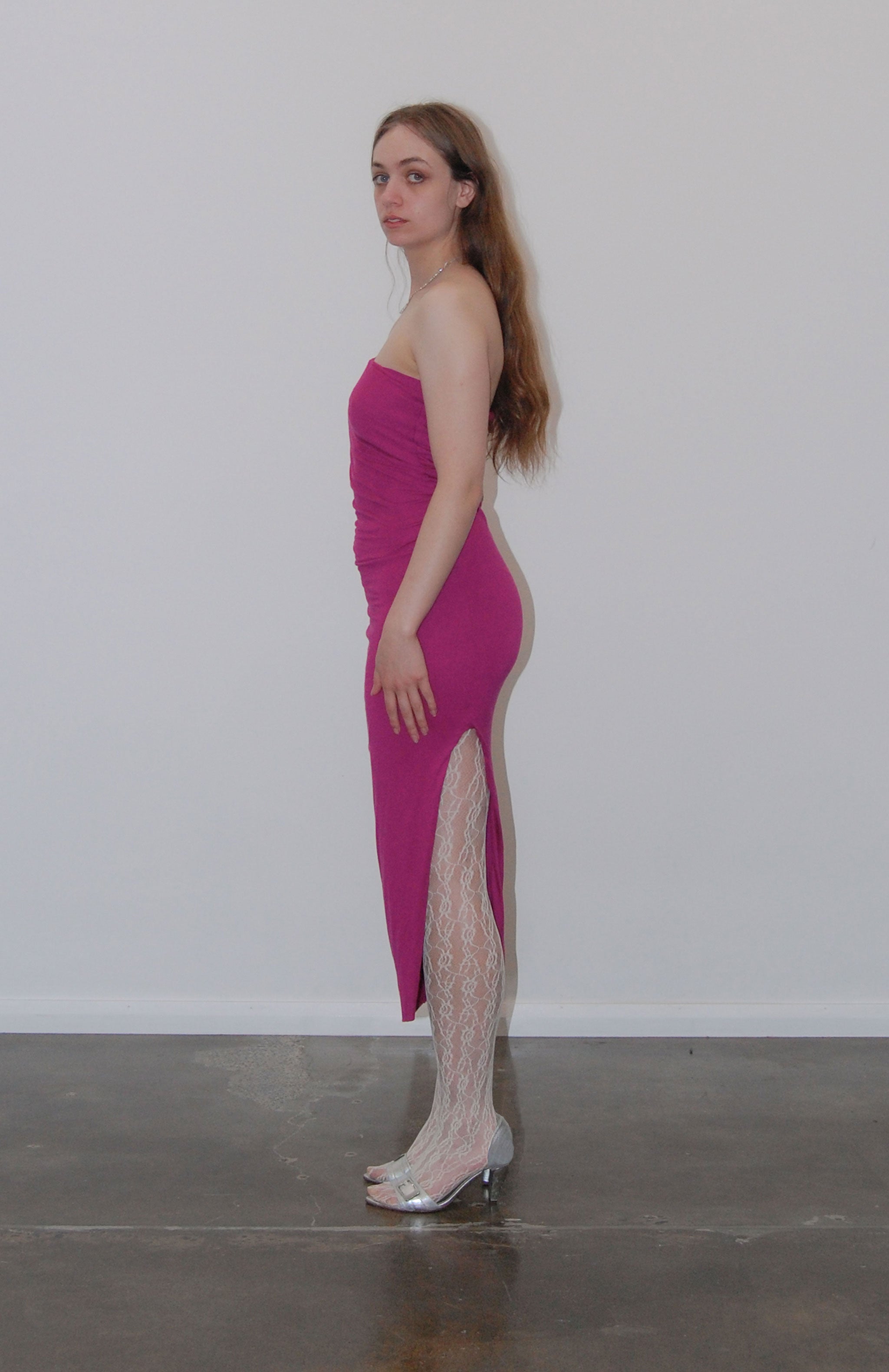 Mid length maxi dress in fuchsia jersey with attached Navy purse pocket. Features, flattering pleats from underarm to the high hip Thigh high slit and adjustable tie spaghetti strap. fully lined with square buckle and magnetic button.