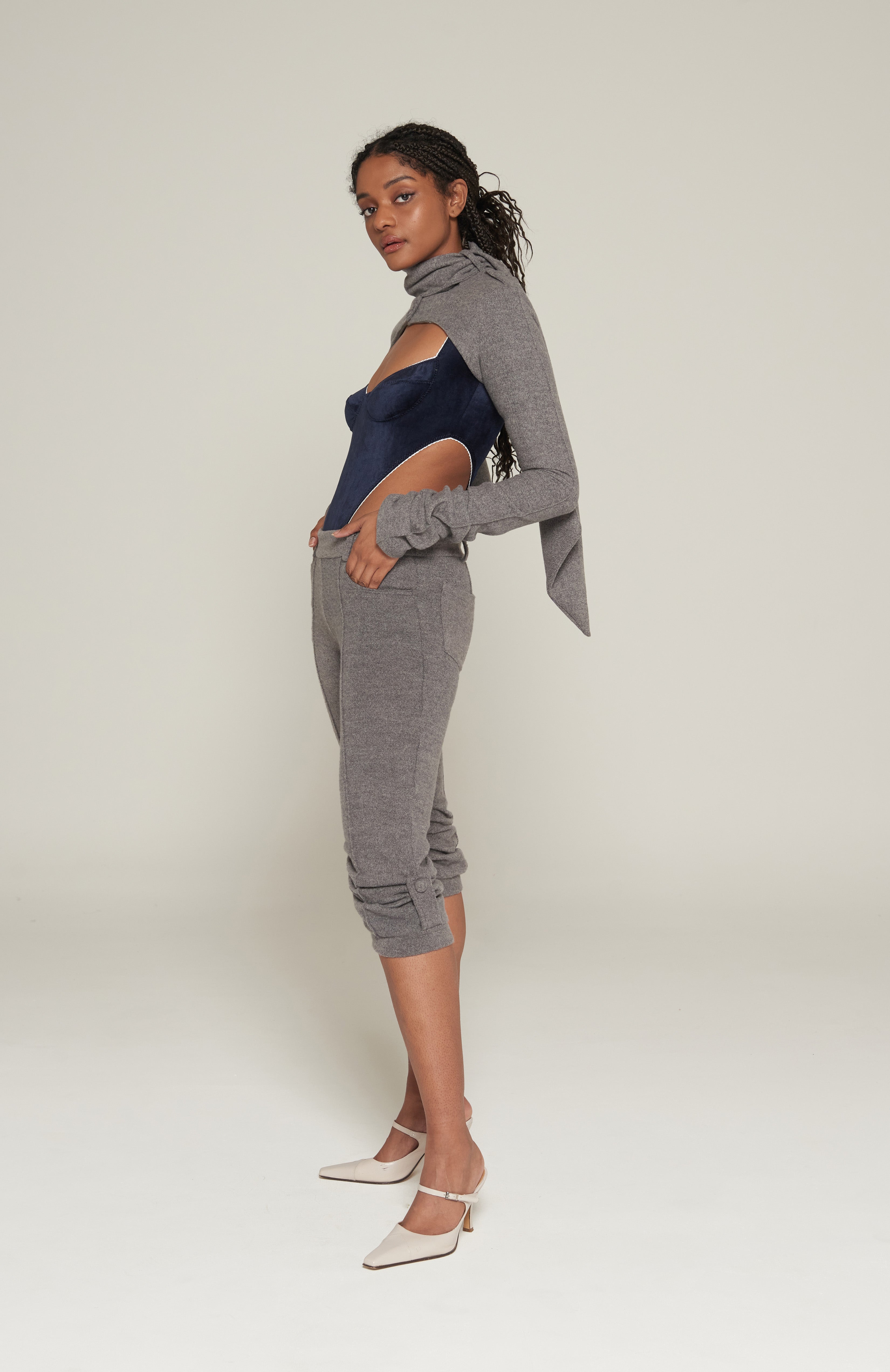 Mid waisted 3/4 capri pant in brushed grey marl. Jean style front pockets with back patch pockets. Features front and back pintucks with gathers at the calf. Aviator epaulette tabs at leg cuffs secured with self covered mushroom buttons. Tidy centre back zip closure and belt loops.