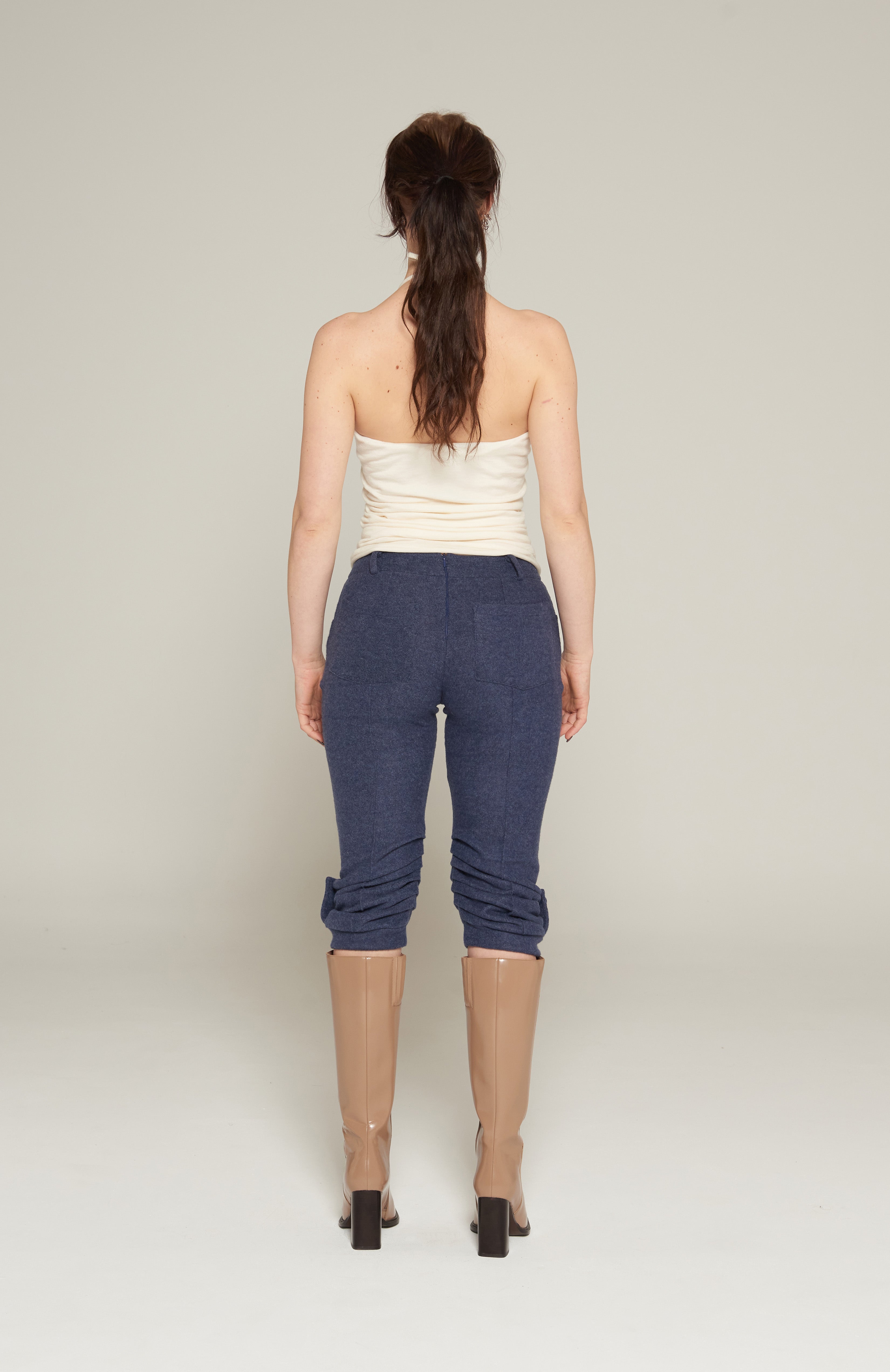 Mid waisted 3/4 capri pants in brushed ink marl. Jean style front pockets with back patch pockets. Features front and back pintucks with gathers at the calf. Aviator epaulette tabs at leg cuffs secured with self covered mushroom buttons. Tidy centre back zip closure and belt loops.