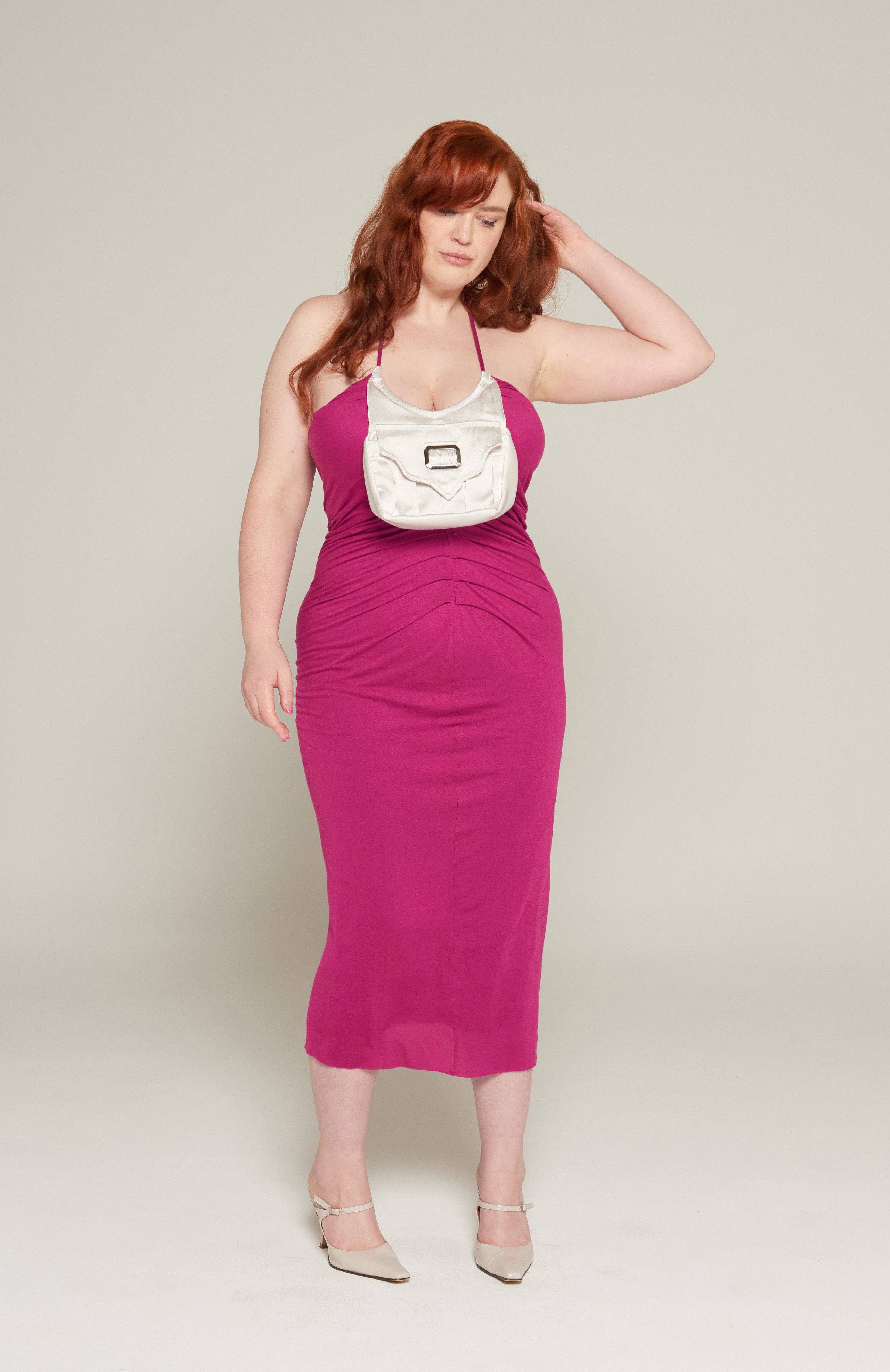 Mid length maxi dress in fuchsia jersey with attached Navy purse pocket. Features, flattering pleats from underarm to the high hip Thigh high slit and adjustable tie spaghetti strap. fully lined with square buckle and magnetic button. 